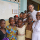 Pfarrer Martin, Sr. Betty und einige Schulkinder