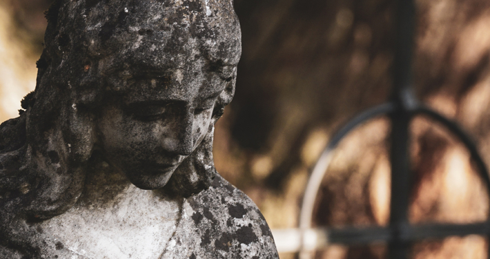 Eine alte Grabskulptur auf einem ländlichen Friedhof