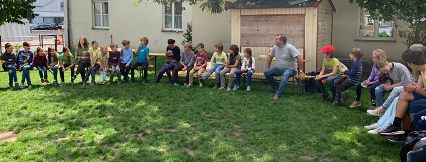 Kinder sitzen im Kreis