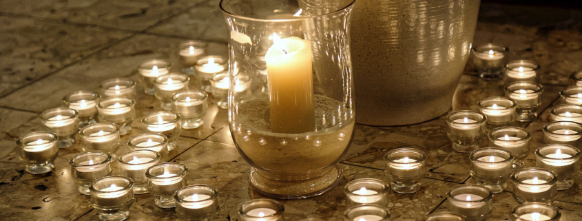 Viele kleine Kerzen um eine große Kerze gruppiert.