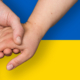 Ukrainische Flagge und drei Hände, die ineinandergreifen