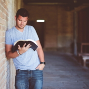 Ein junger Mann, der die Bibel im Stehen liest