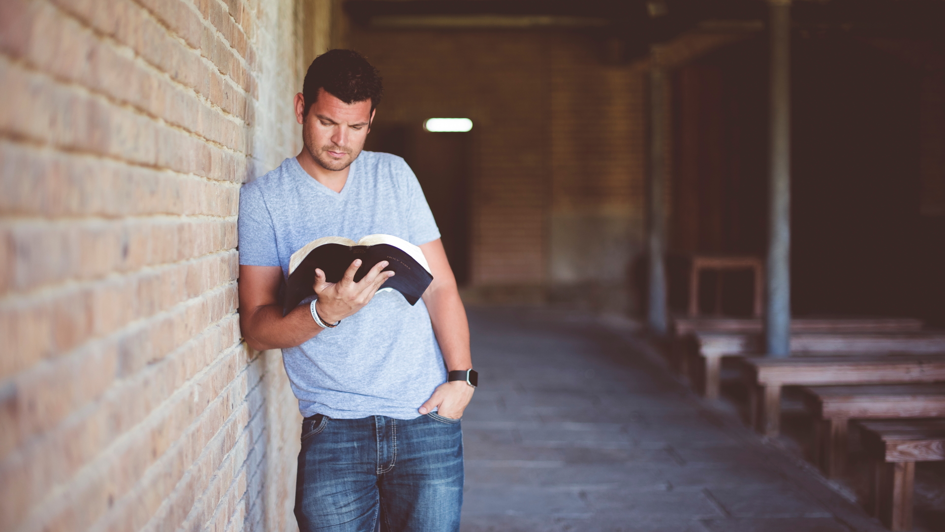 Ein junger Mann, der die Bibel im Stehen liest