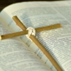 Ein Kreuz aus zwei Zweigen, das auf einer Bibel liegt