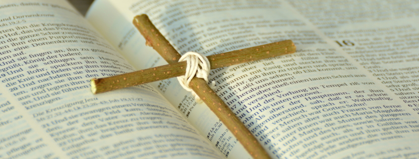 Ein Kreuz aus zwei Zweigen, das auf einer Bibel liegt