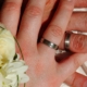 Zwei Hände mit Eheringen und weißen Blumen