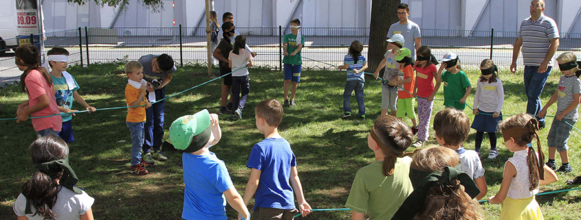 Eine große Gruppe Kinder spielt ein Vertrauensspiel