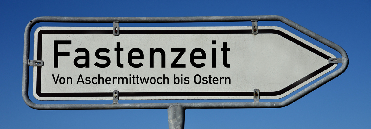 Ein Wegweiser mit der Aufschrift "Fastenzeit - von Aschermittwoch bis Ostern"