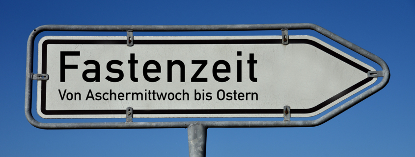 Ein Wegweiser mit der Aufschrift "Fastenzeit - von Aschermittwoch bis Ostern"