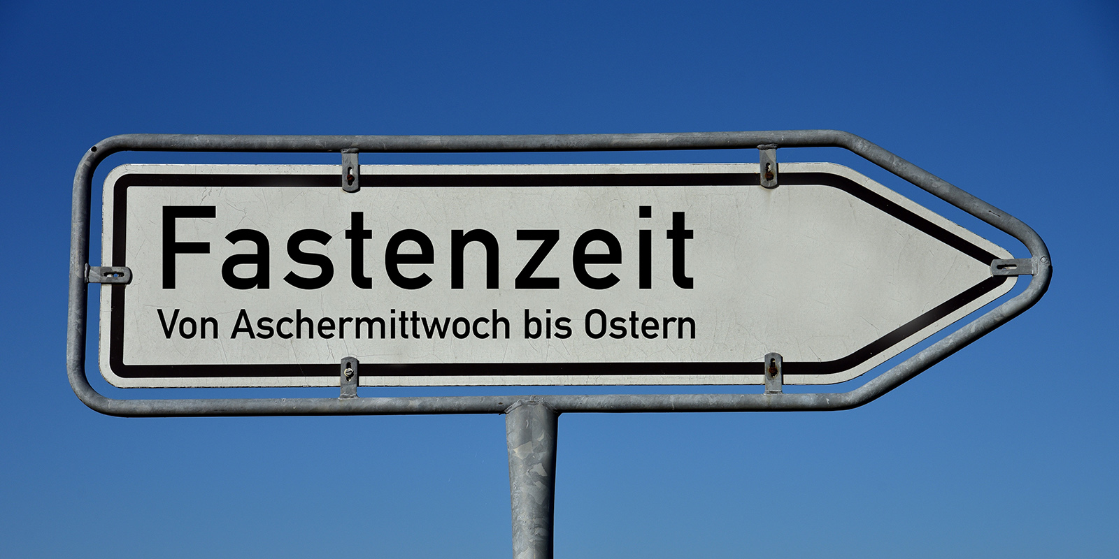 Ein Wegweiser mit der Aufschrift "Fastenzeit - von Aschermittwoch bis Ostern"