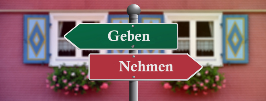 Zwei Wgweiser mit Geben und Nehmen