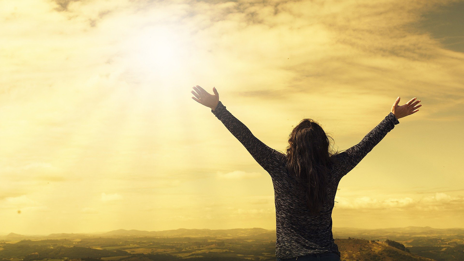 Eine junge Frau begrüßt die Sonne