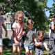 Kinder springen von einem Baumstamm