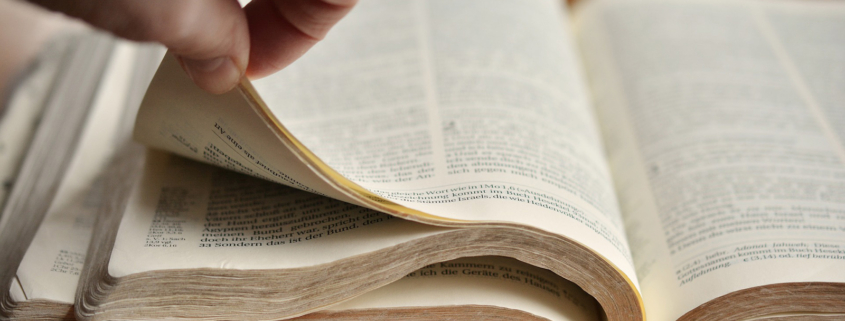 Eine Hand, die in einer Bibel blättert