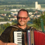 Peter Hackl mit Akkordeon vor Weingärten