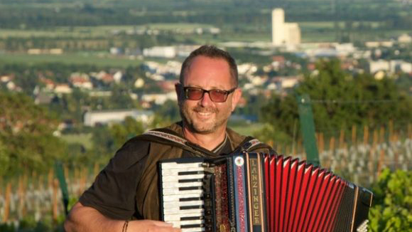 Peter Hackl mit Akkordeon vor Weingärten