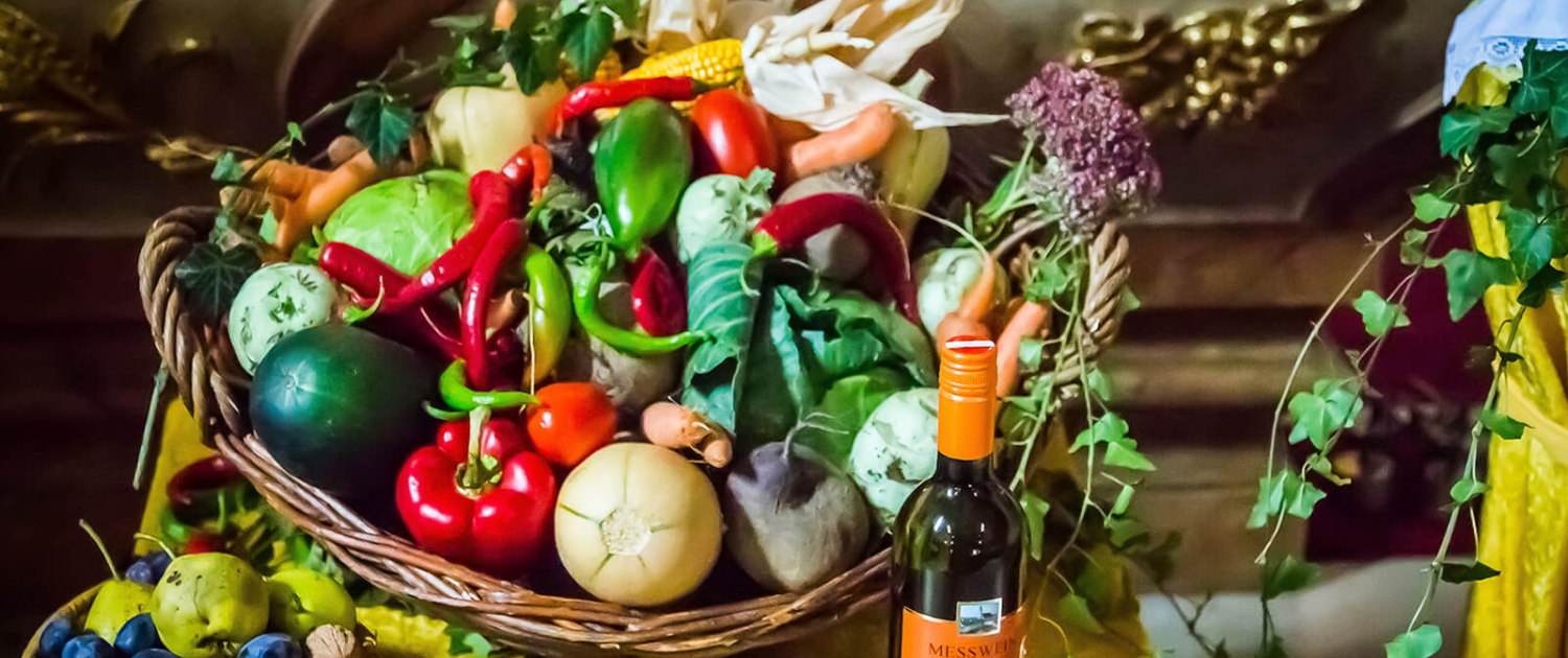 Erntedank Korb Obst und Gemüse in Körben und eine Flasche Messwein