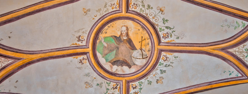 Ein Kreuzrippengewölbe mit Blumenornamenten und Jesus im Himmel als Schlussstein