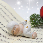 Eine Christbaumkugel und ein Porzellanengel auf einem Notenbuch