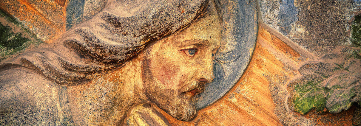 Ein Holzrelief von Jesus Christus der das Kreuz trägt