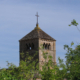 Der Kirchturm der Kirche von Taizé vor blauem Himmel