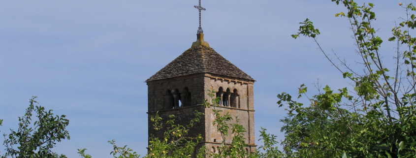 Der Kirchturm der Kirche von Taizé vor blauem Himmel