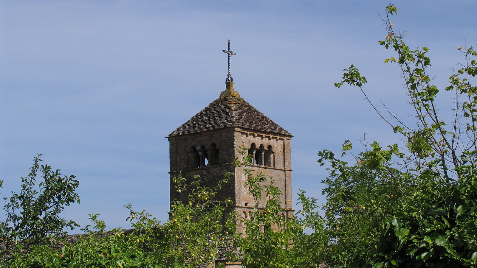 Der Kirchturm der Kirche von Taizé vor blauem Himmel