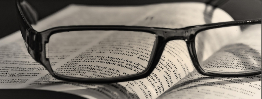 Brille liegt auf einer Bibel