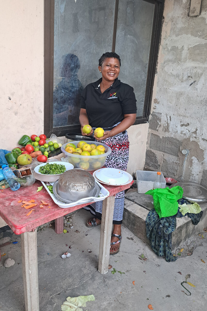Eine Köchin aus Dar es Salaam bereitet das Abendessen für die Besucher/innen