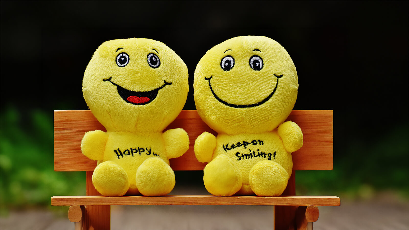Zwei Smiley-Puppen mit den Aufschriften "Happy" und "Keep on Smiling"